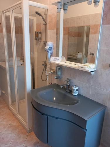 W łazience znajduje się niebieska umywalka i prysznic. w obiekcie Bed & Breakfast Nettuno w Trydencie