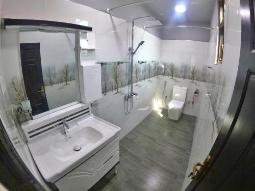 a white bathroom with a sink and a toilet at Juliya Guest House in Negombo