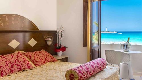 a bedroom with a bed with a view of the beach at Hotel Egitarso Sul Mare in San Vito lo Capo