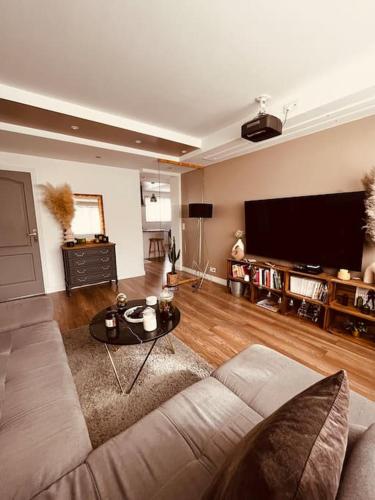 un salon avec un canapé et une télévision à écran plat dans l'établissement Appartement proche de Paris, à Sartrouville