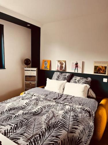 une chambre avec un lit avec une couette noire et blanche dans l'établissement Appartement proche de Paris, à Sartrouville