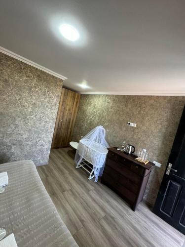 a bedroom with a bed and a dresser and a sink at Odamarani in Kutaisi
