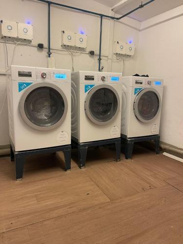 4 lave-linge et un lave-linge/sèche-linge dans une pièce dans l'établissement Wegener Apartments, à Mannheim