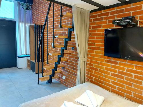 een stenen muur met een tv en een stenen trap bij Apartament typu studio Morski Sen-centrum in Mielno