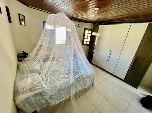 1 cama con mosquitera en una habitación en Casa com grande piscina e garagem. 5 min da Orla, en Paulista