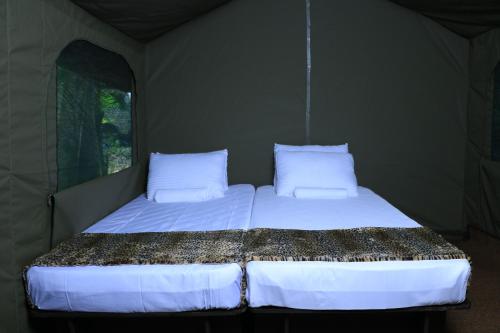 a bedroom with two beds in a tent at Leopard Glamping - Luxury Mobile Campsite in Yala & Kumana in Matara