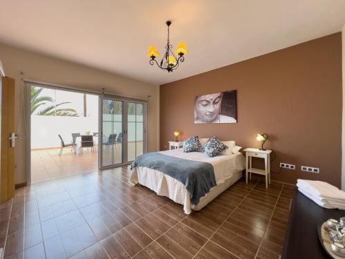 - une chambre avec un lit et un lustre dans l'établissement Villa Rosa Maria, à Tacoronte