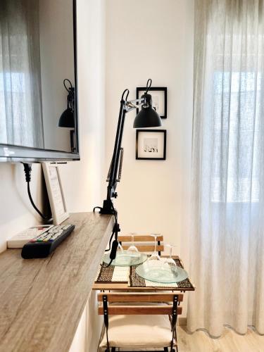 a desk with a computer and a lamp on it at VIATOREM Suites in Torre dell'Orso