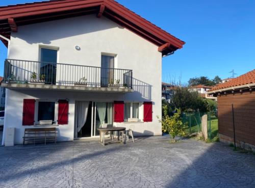 een wit huis met een tafel en een balkon bij Maison Basque mitoyenne tout confort in Hendaye