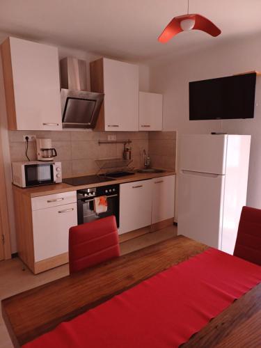 a kitchen with white cabinets and a red rug at Haus Piller in Bad Hofgastein