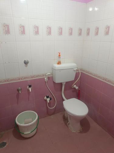 a bathroom with a toilet and a bucket in it at COIMBATORE 2BHK AC Private Villa By Shivalaya -Kovaipudur- in Coimbatore
