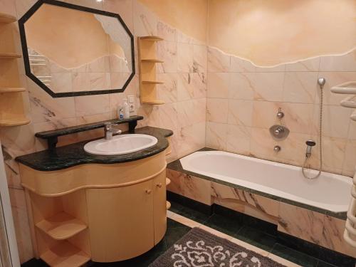 a bathroom with a sink and a tub and a mirror at Apartment Kerer in Wald im Pinzgau