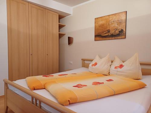 ein Schlafzimmer mit einem Bett mit einer orangefarbenen Decke in der Unterkunft Apartment Kerer in Wald im Pinzgau