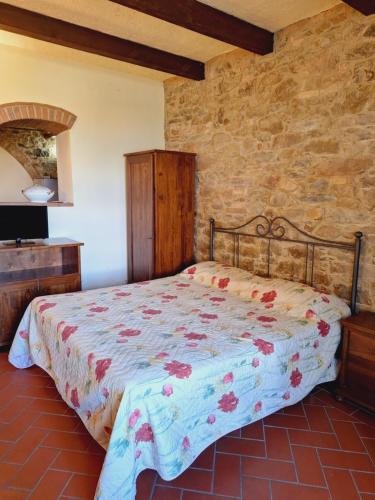 a bedroom with a bed in a stone wall at Casa Amedeo in Chianni