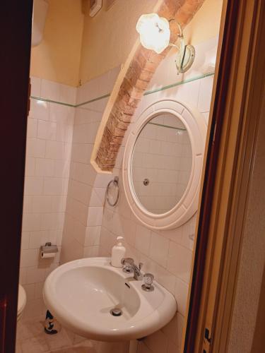 een badkamer met een wastafel en een spiegel bij Casa Amedeo in Chianni