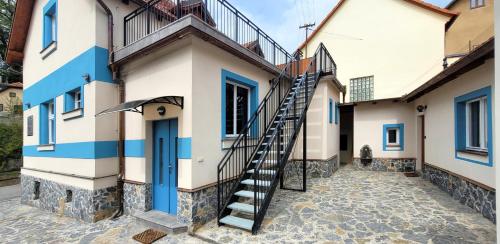 eine Treppe, die zu einem Haus mit blauen Akzenten führt in der Unterkunft Bunkr Karlštejn in Karlštejn