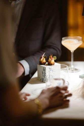 a person sitting at a table with a dessert and a drink at Château Neercanne - Oostwegel Collection, member of Relais and Châteaux in Maastricht