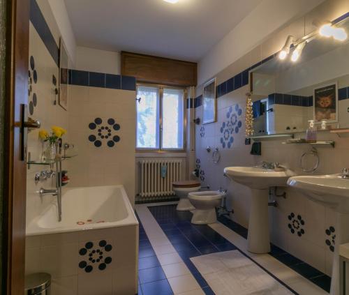 a bathroom with two toilets and a tub and a sink at Welcomely - La Soliva Big House in Primaluna