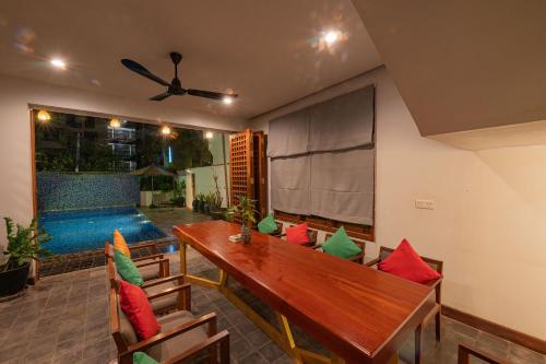 a dining room with a table with colorful pillows at Homewood Hotel By Seuya Hotel in Siem Reap