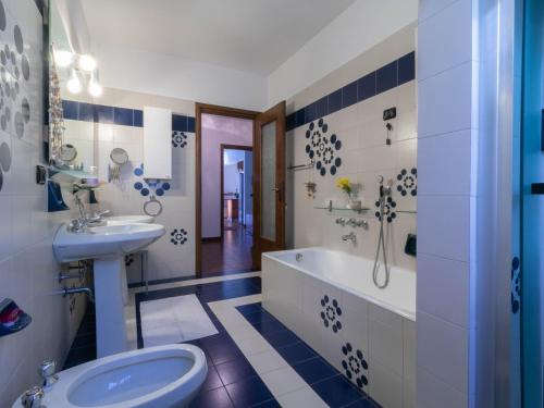 a bathroom with a sink and a tub and a toilet at Welcomely - La Soliva Big House in Primaluna