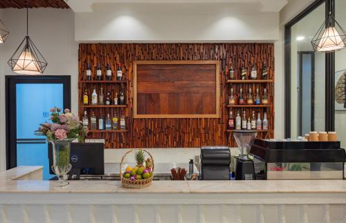 a bar with a counter with fruit and wine bottles at Homewood Hotel By Seuya Hotel in Siem Reap