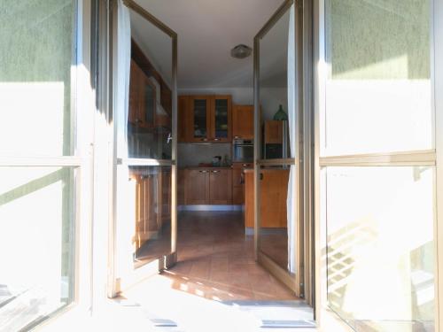 a kitchen with two large sliding glass doors and a kitchen with at Welcomely - La Soliva Big House in Primaluna
