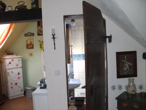 baño con lavabo, espejo y puerta en Haus Klara, en Mannebach