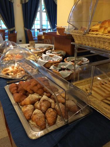 a table filled with different types of pastries and bread at Hotel Lario in Mezzegra