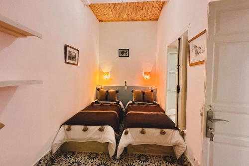 a bedroom with three beds in a room at Riyad zen oasis in Essaouira