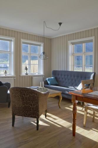 a living room with a blue couch and a table at Lónsleira Apartments in Seyðisfjörður