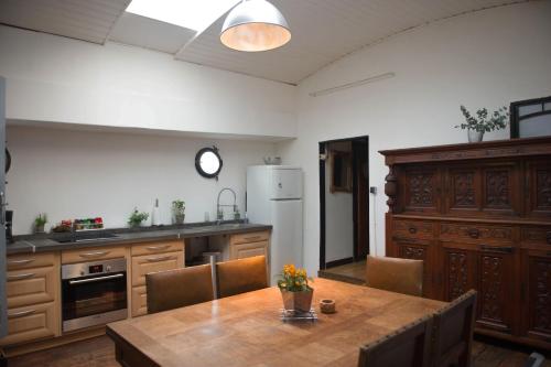 une cuisine avec une table et un réfrigérateur blanc dans l'établissement Péniche à 25 mn de Paris, à Creil
