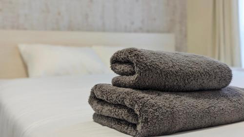sterta ręczników na łóżku w obiekcie 与那国むんぶステイ空港前 w mieście Sonai