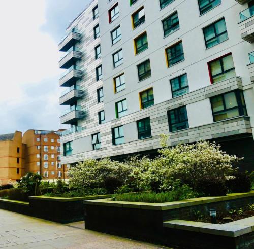 a tall white building with bushes in front of it at Luxury Flat Town Centre in Reading