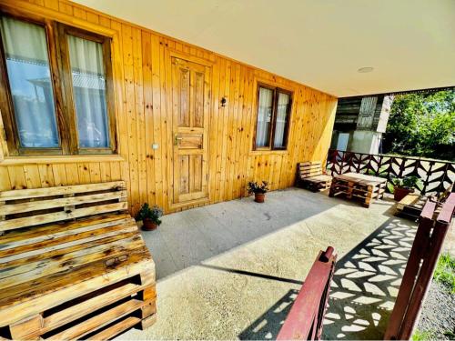 a porch of a wooden house with a bench at Odamarani in Kutaisi