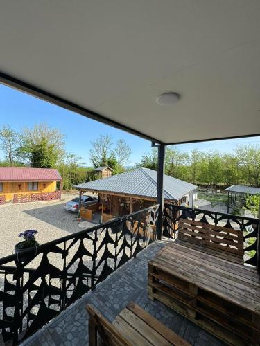 a balcony with a wooden bench and a building at Odamarani in Kutaisi