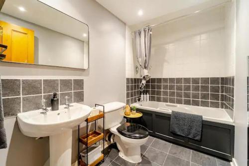 a bathroom with a sink and a toilet and a tub at Spacious 1-Bed City Centre Apartment in Aberdeen in Aberdeen