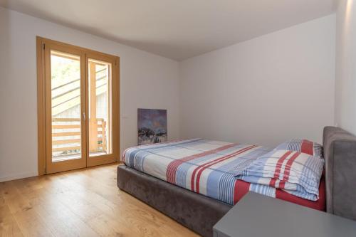 a bedroom with a bed and a sliding glass door at La Casa di Sofia in Alleghe