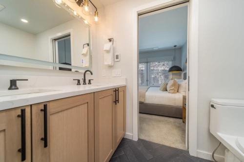een badkamer met een wastafel, een spiegel en een bed bij New Listing Renovated 3BR with AC & Pool in Aspen