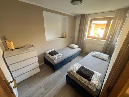 a small room with two beds and a window at Meta pod dębem in Bielsko-Biała