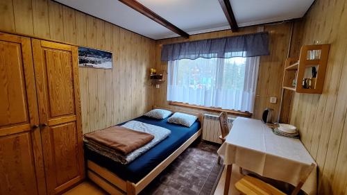 Habitación pequeña con cama y mesa en Domek u Gąsieniców 1 - pokoje gościnne, en Zakopane