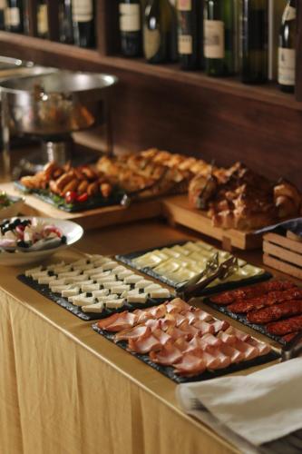a buffet with many different types of food on a table at Agape Villa Apartments in Novi Sad