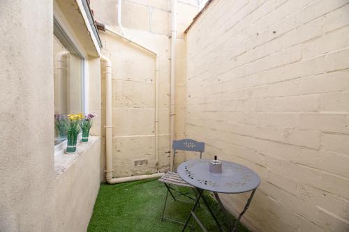 una mesa pequeña y una silla en una habitación pequeña en La Perle de Cognac, en Cognac