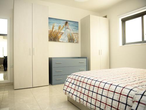 1 dormitorio con 1 cama y una pintura en la pared en Seaview-CasadiAlfio-Qawra, en St Paul's Bay