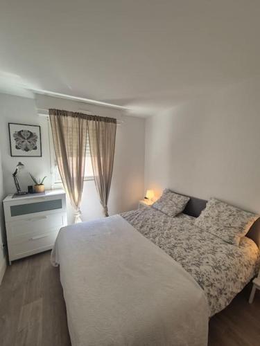 une chambre avec un grand lit et une fenêtre dans l'établissement Appartement T2 - Hyères GARE, à Hyères