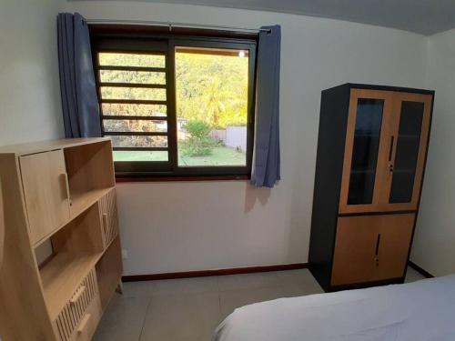 1 dormitorio con ventana, 1 cama y vestidor en Paea Lodge en Paea