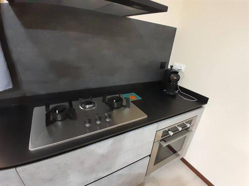 a kitchen with a black counter top with a sink at Paea Lodge in Paea