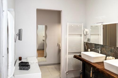 a white bathroom with two sinks and a shower at Il risveglio del Poggio in Castiglione dʼOrcia