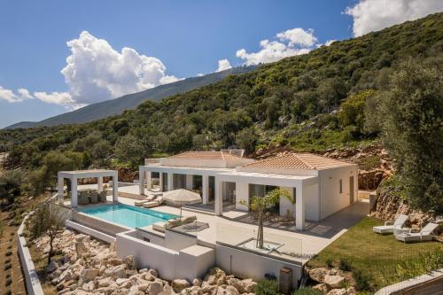 a house with a swimming pool and a mountain at Villa Templin in Chaliotata