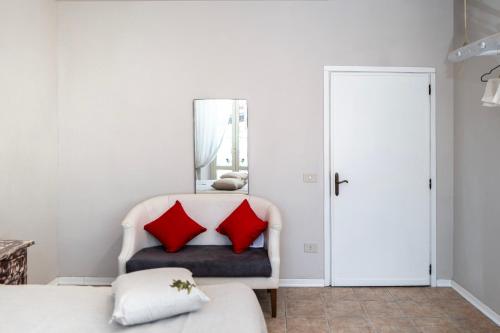 a bedroom with red pillows on a white couch at Il risveglio del Poggio in Castiglione dʼOrcia