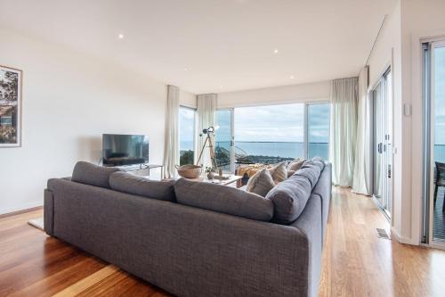a living room with a couch and a large window at Cook's Lookout McCrae in McCrae